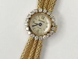 an image of a woman ' s wrist watch with a chain around it