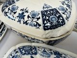 several blue and white plates and bowls on a white table