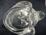 a clear glass pig shaped object on a black surface