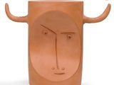 a clay vase with a face on it