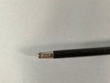 a black pencil that is laying on a white surface