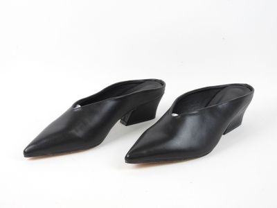 une paire de mules en cuir noir sur fond blanc