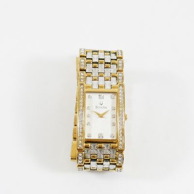 une image d'un gros plan d'une montre-bracelet sur une surface blanche