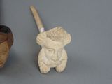 a pipe and a pipe holder sitting next to each other on a table