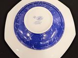 a blue and white plate on a black table
