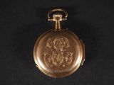 a gold pocket watch on a black background