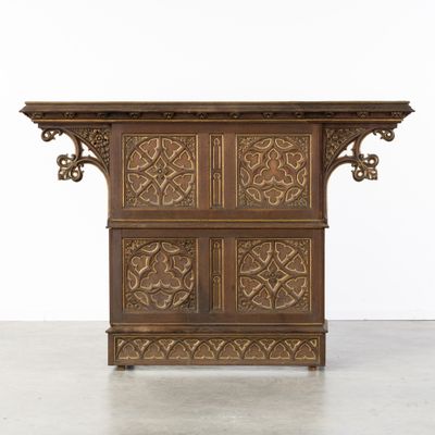 une vieille armoire en bois ornée de sculptures sur le dessus