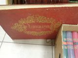 a box of books sitting on the floor next to a box of candles