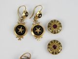 trois paires de boucles d'oreilles et une broche posées sur un fond blanc