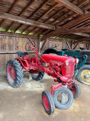 deux vieux tracteurs dans une grange au toit en bois