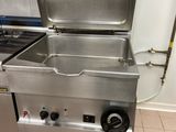 a large stainless steel stove in a kitchen with two burners