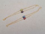 a pair of multicolored glass beads on a gold chain