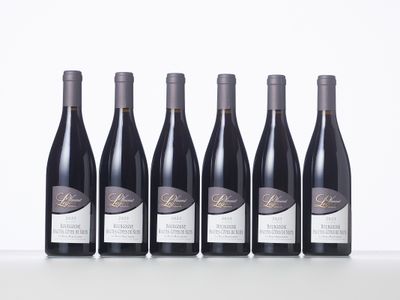 six bottles of wine lined up in a row on a table