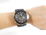 someone is holding a watch on their wrist on a white surface