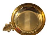 a gold plate with a leaf on it on a white background