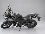 a black motorcycle that is parked on a gray floor