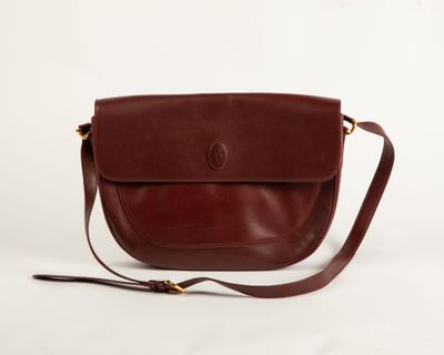 MUST DE CARTIER Sac besace en cuir bordeaux, accastillage en…