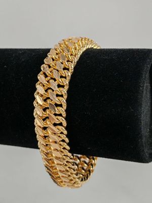 a gold bracelet on a black ring holder