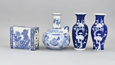 trois vases bleus et blancs et une boîte posés sur une surface grise