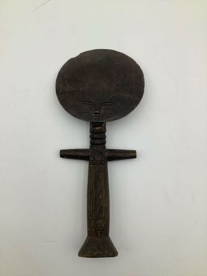 an old wooden spoon with a wooden handle on a white surface