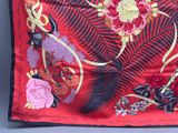 an image of a red silk scarf with flowers and feathers