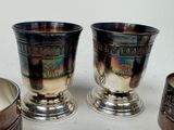 three silver cups sitting next to each other on a table