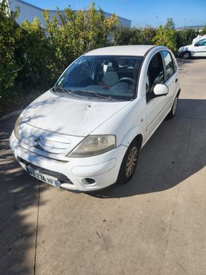 une petite voiture blanche garée sur le bord de la route