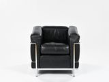 black leather chair with chrome legs and armrests against a white background