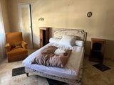 a bed and a chair in a room with a window