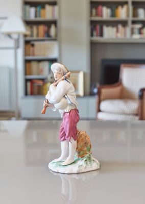 une figurine représentant un homme jouant de la flûte dans un salon