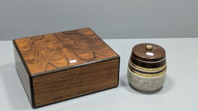une petite boîte en bois avec un couvercle, posée à côté d'un petit bocal