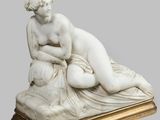 une photo représentant une statue d'une femme allongée sur une table