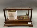 une vitrine en bois contenant un baromètre