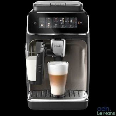 Il y a un verre de lait devant la machine à café.