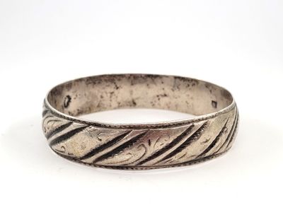 gros plan d'une bague en argent sur une surface blanche