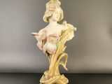 an antique figurine of a woman with flowers in her hair