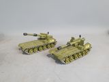 two toy army tanks sitting on top of a table next to each other