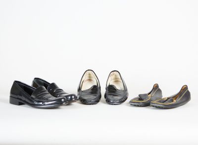 trois paires de chaussures noires sont alignées sur une surface blanche