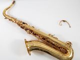a saxophone that is laying on a white surface