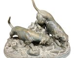 statue of a group of dogs playing with a ball on a rock