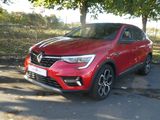 La voiture rouge est garée sur le bord de la route.
