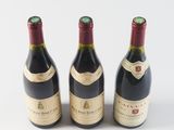 three bottles of wine are lined up on a white surface