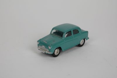 une petite voiture miniature posée sur une surface blanche
