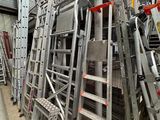 many ladders that are stacked up in a warehouse