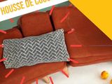 a picture of a couch with a pillow and oranges on the floor