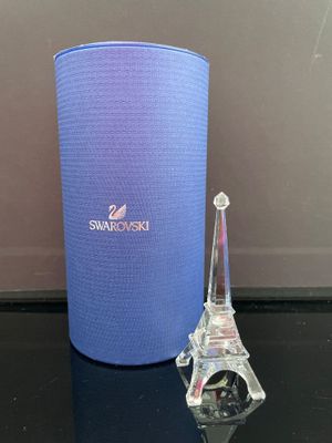 une petite tour en verre à côté d'un conteneur bleu