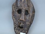 un gros plan d'un masque en bois muni d'une étiquette