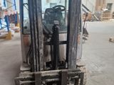 a forklift in a warehouse with a lot of pallets
