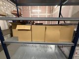 une étagère sur laquelle sont posées des boîtes, au milieu d'une pièce