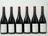 six bouteilles de vin sont alignées sur une table